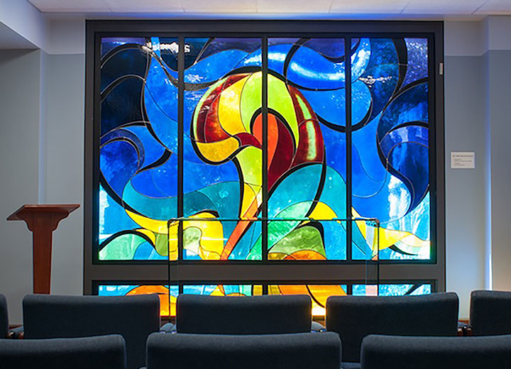 “In the Beginning,” a 2001 stained-glass work by Genevieve Underwood, R.S.H.M., displayed in the Interdenominational Chapel for Prayer and Peace in LMU’s University Hall.